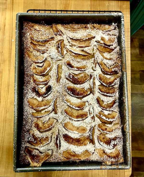 Italian Apple Cake still in the pan dusted with powdered sugar