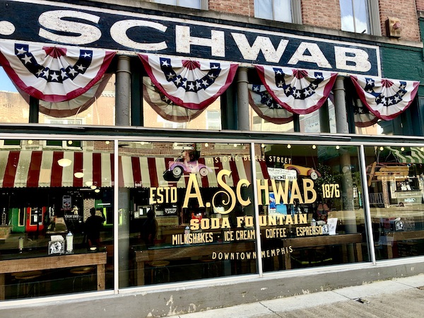 The store front for Schwab's is festooned with red white and blue.