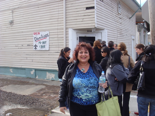 A woman in a blue top waiting on line at Domilise's in NOLA from Best Po' Boys Domilise's vs Acme