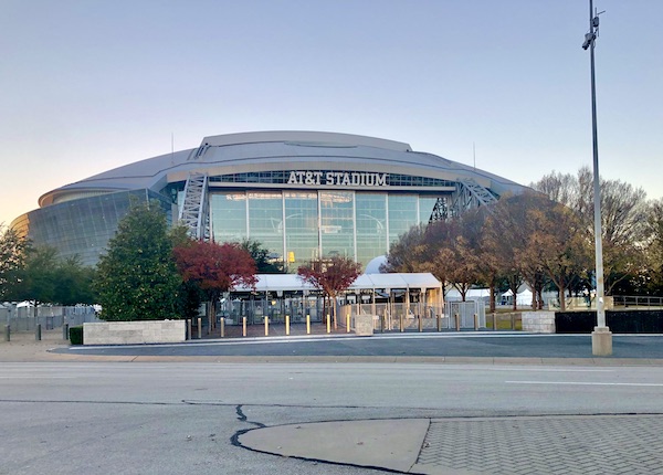 A domed football stadium with a glass front entry.
