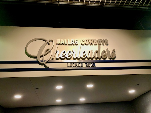 White wall with blue stripes and brushed aluminum letters.
