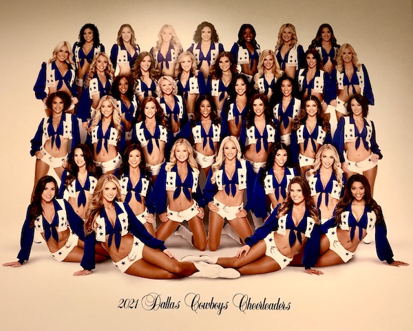 A photo of a large group of women in blue and white cheerleader outfits seen on our Dallas Cowboys Stadium Tour