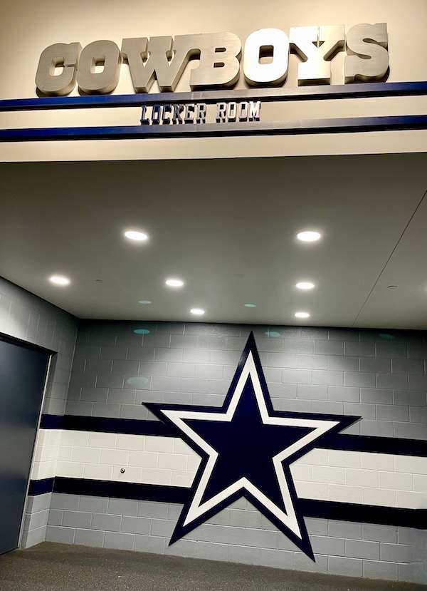 A gray wall with a white stripe and star at our Dallas Cowboys Stadium Tour