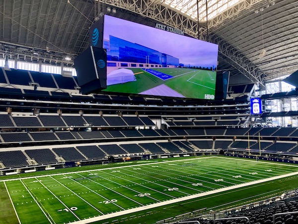 A football stadium with Jumbotrons, field and seating visible during our Dallas Cowboys Stadium Tour