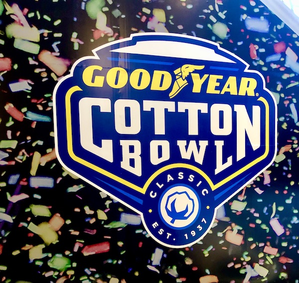 A blue sign with white writing announcing the Good Year Cotton Bowl.