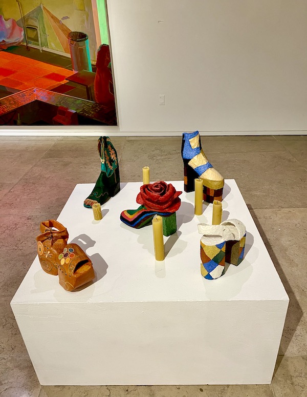 A low white table displaying whimsical shoes made of wood at AcA in Downtown Lafayette Louisiana