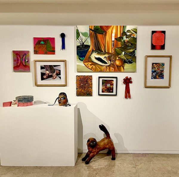 Art displayed on a white wall and white pedestals at AcA in Downtown Lafayette Louisiana