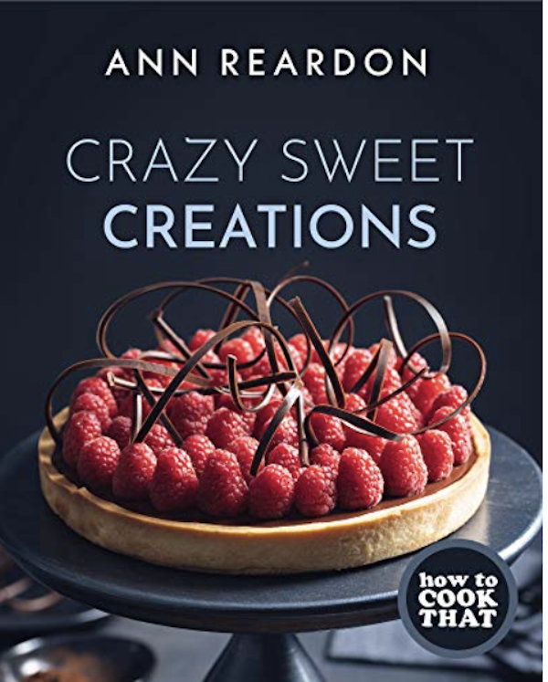 A book cover with a black background and a raspberry tart from Exciting New and Delicious Products