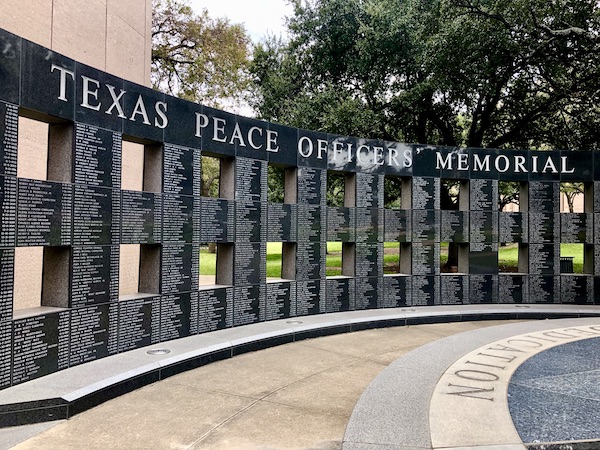 A curved black granite wall with names inscribed.