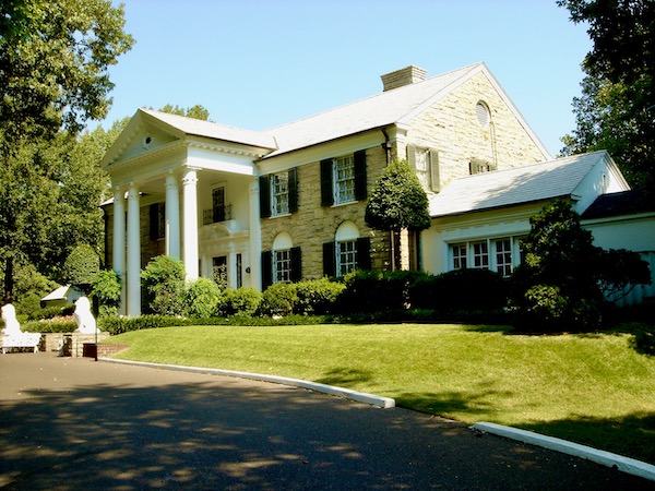 A large colonial style home with stone front and white pillars.