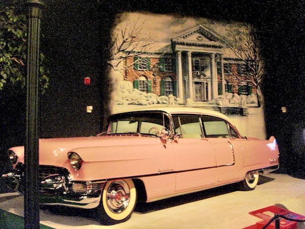 An old 1950s pink Cadillac with a white top.