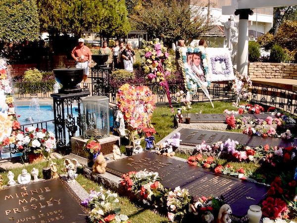 A family cemetery plot with flower at the graves and lots of visitors.