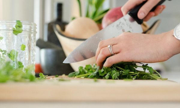 A woman's hands holding and cutting vegetables with a chef's knife from How to be Mindful of What Goes into Your Food