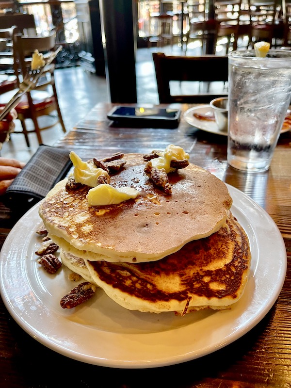 A white plate topped with a stack of pancakes on a restaurant table in Wonderful Galveston Island Texas