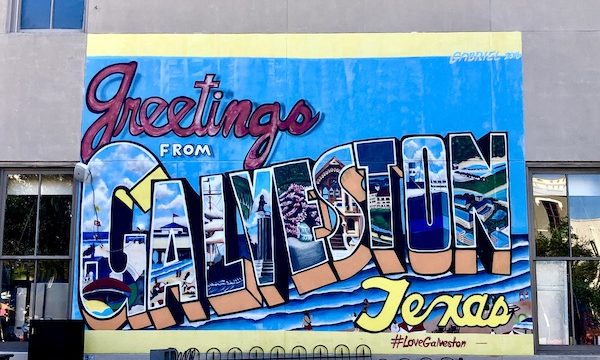 A colorful mural on a building says Greetings from Galveston Texas