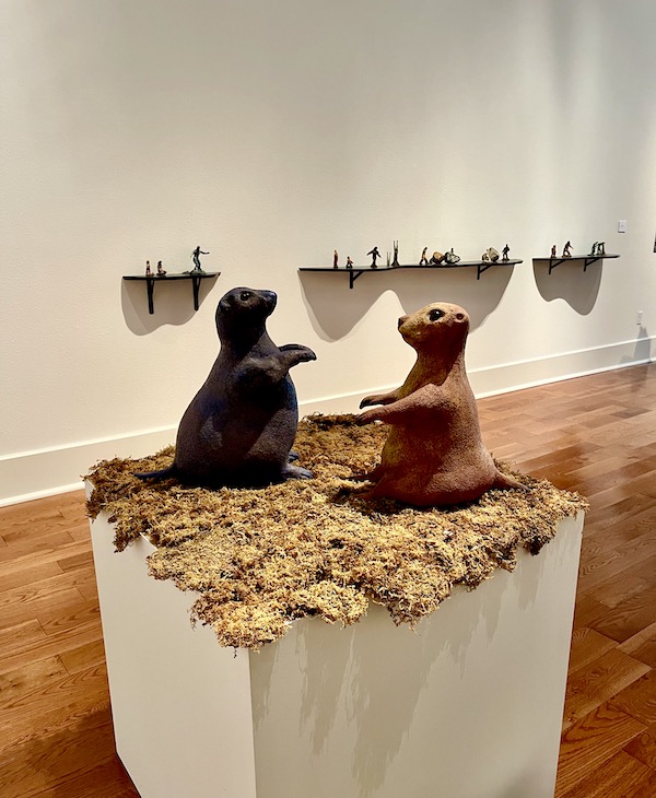 A square pedestal with a pair of clay chipmunks on top.