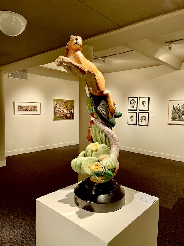 A wood, color tinted sculpture of a lion, reptile and cactus viewed at Abilene Art Walk and Pizza