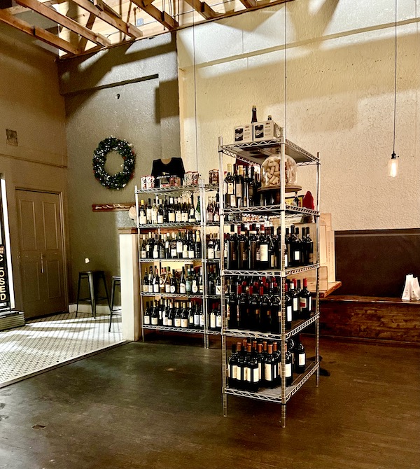 Wire rack shelving holds bottle of wine during Abilene Art Walk and Pizza