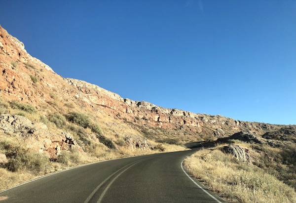 A road curving along rocky mountains at Bottomless Lakes State Park Roswell NM