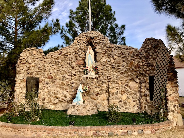 Stone shrine with kneeling woman sculpture and statue of the Madonna seen along the El Paso Texas Mission Trail
