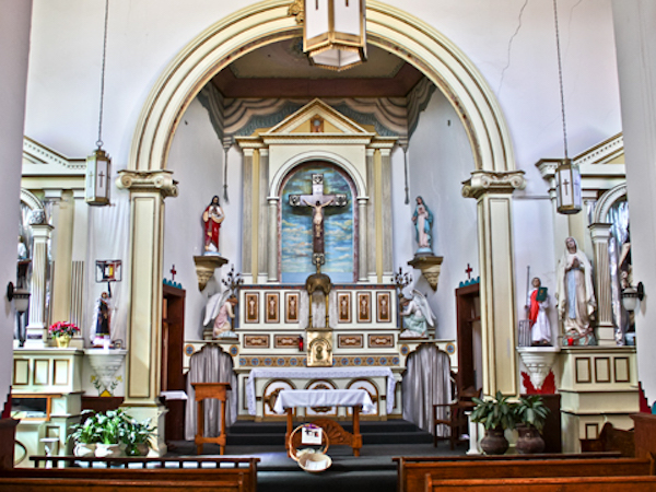 A large arch housing a church altar with gold paint.