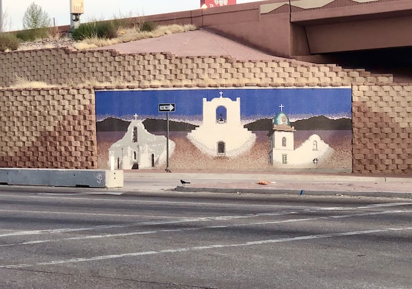 A mural on the highway depicting 3 white churches along the El Paso Texas Mission Trail