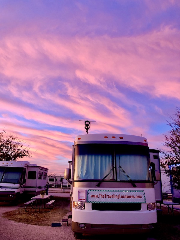 A vivid pink and purple sunset behind our RV.