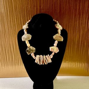 A pink necklace on a black velvet display is a Peruvian Pink Opal Necklace