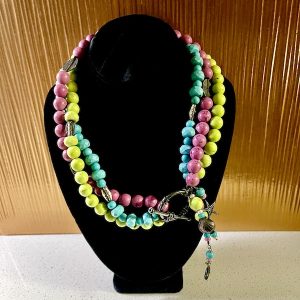 Pink Lime Green and Turquoise Dyed Howlite Necklace on a black velvet neck display
