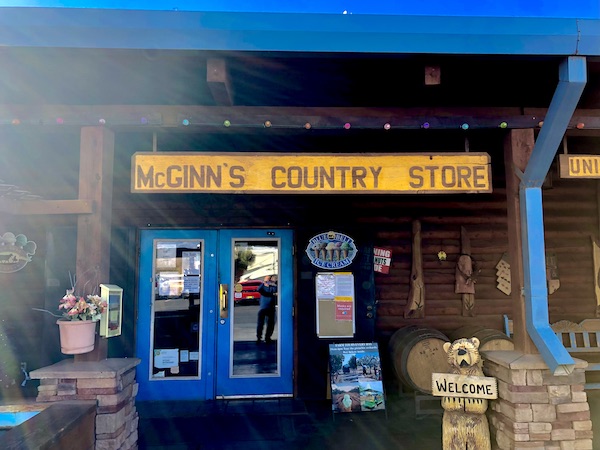 A yellow sign over the porch of a country store with blue doors at the World's Largest Pistachio Alamogordo NM
