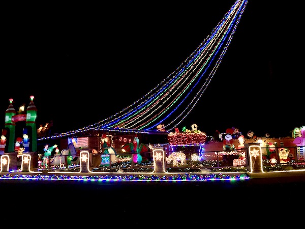 A couple of houses all lit up for Christmas at night.