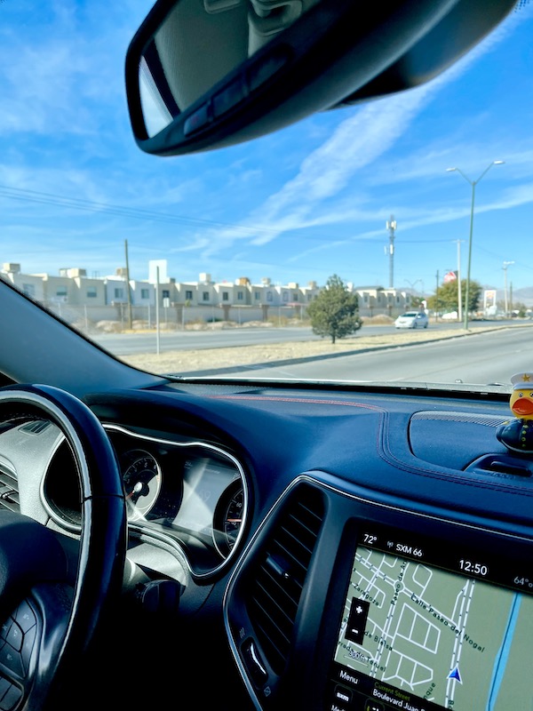 A row of white homes seen through the windshield of a Jeep from Our Trip to Mexico and Lunch
