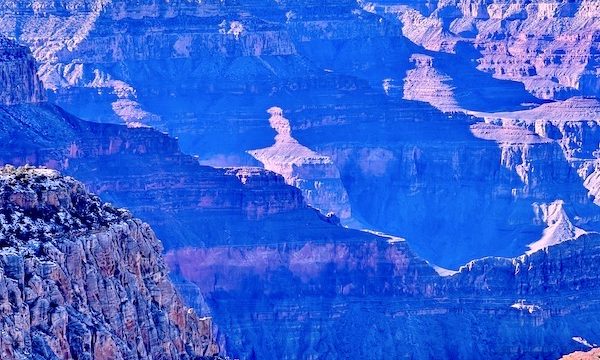 A view of the South Rim Grand Canyon Arizona with sunlight making it look purple.