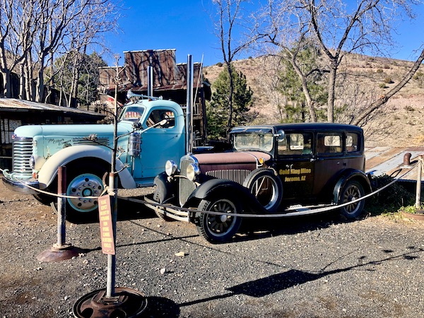 An aqua antique truck and old brown car at Friendly Ghost Town Haynes AZ