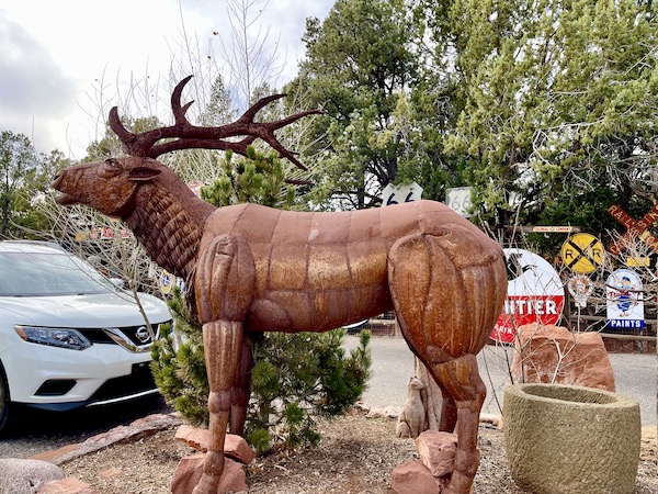 Huge rust colored statue of a reindeer near the Red Rocks of Sedona Arizona