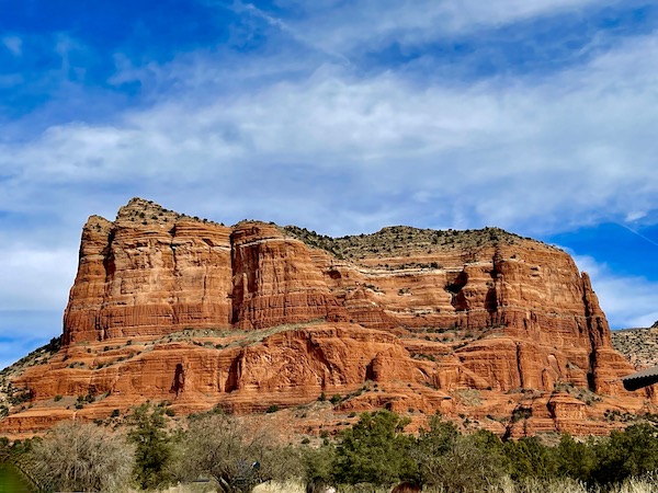 Red Rocks of Sedona Arizona with a row of trees in front.