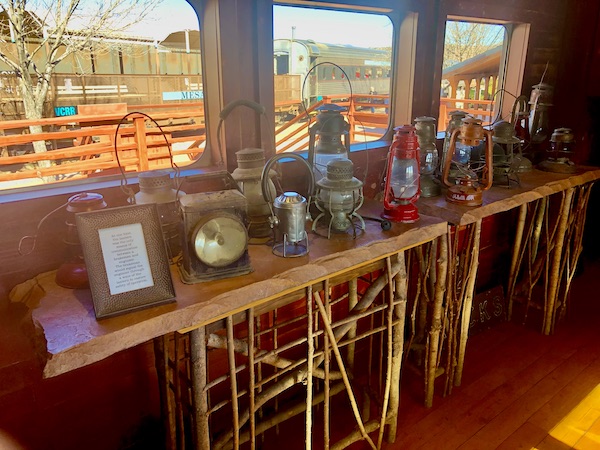 A long narrow table topped with and assortment of old lanterns at the station for the Verde Canyon Railroad Wilderness Route