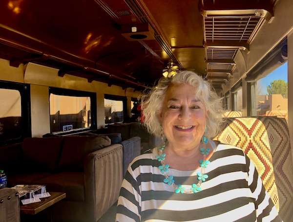 A silver haired woman in a black and white striped top sitting in a train car on the Verde Canyon Railroad Wilderness Route