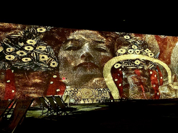 Portrait of a woman with colorful shapes superimposed over it at the Gustav Klimt: The Immersive Experience