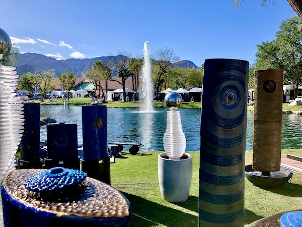 Assorted glass and ceramic fountains displayed by a lake at La Quinta Art Celebration California