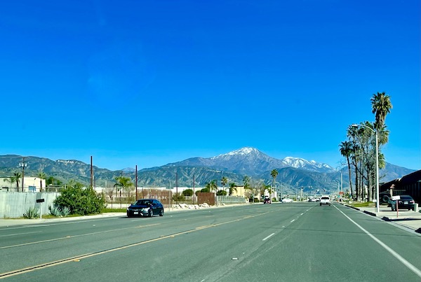 A highway with vehicles and snow capped mountains in the distance on our way to Lake Arrowhead California