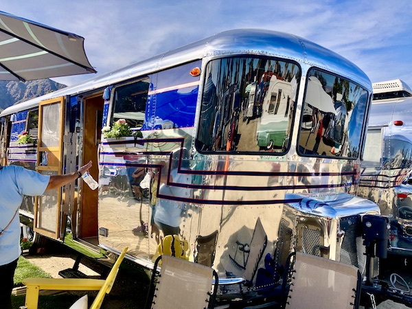 A shiny all metal vintage camper with cobalt blue trim at the Palm Springs CA Vintage Trailer Show