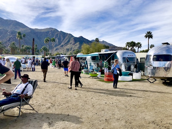 A camper show area with people, campers and mountains at the Palm Springs CA Vintage Trailer Show