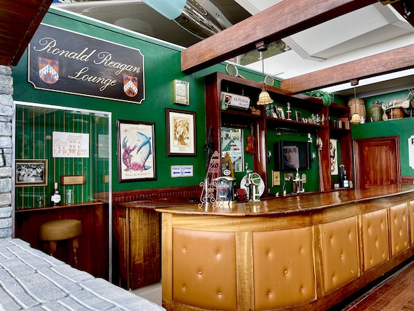 A blond wood bar with pictures hanging on a dark green wall at Ronald Reagan Presidential Library