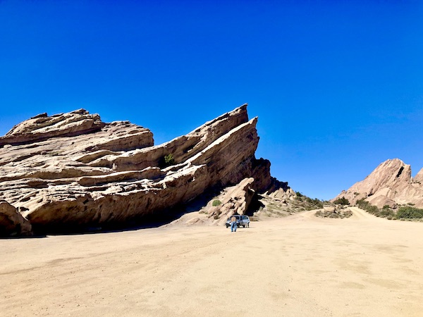 Angular rocks point to the sky, a man and a car at Vasquez Rocks Agua Dulce CA