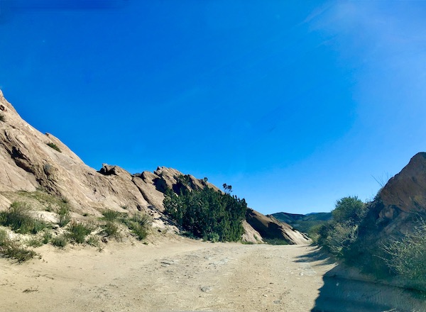 Sand, rocks and bushes with bright blue sky at Vasquez Rocks Agua Dulce CA