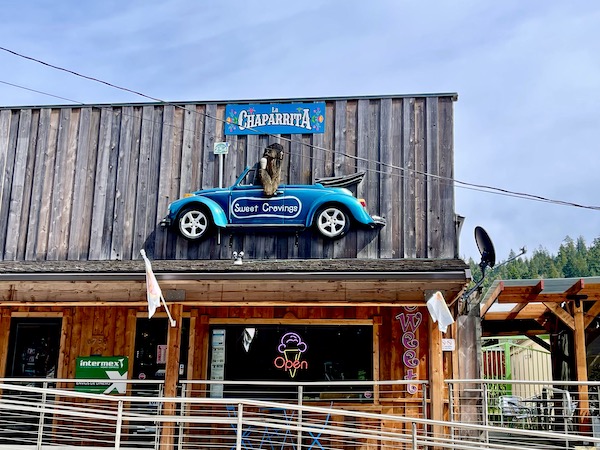 An old west style building with a 3-D car above the windows on the