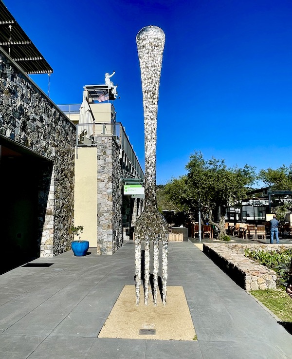 A huge fork sculpture in front of a stone and stucco building seen while having Fun in Downtown Napa CA