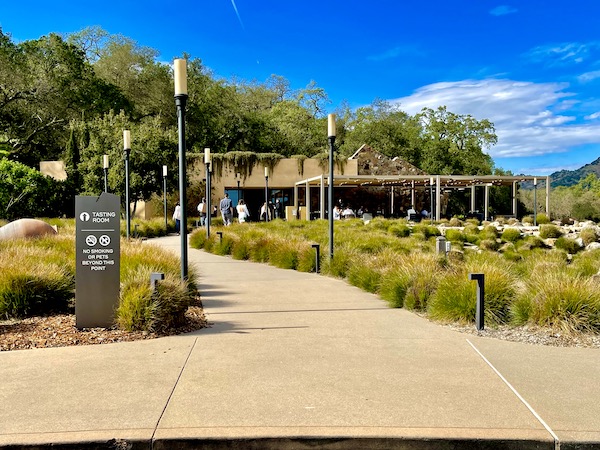 A building with covered patio, landscaping, paths and people on our Napa Valley Winery Tour
