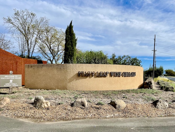 A tan stucco entry wall with landscaping welcomes you to Stag's Leap Wine Cellars on our Napa Valley Winery Tour